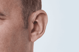 Appareil auditif Oticon More, modèle miniRITE R, couleur Gris clair, photo prise de face sous un angle de 45°, Gros plan sur l'oreille, Homme Appareils auditifs avec service illimité Auzen
