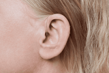Appareil auditif Oticon More, modèle miniRITE R, couleur Gris clair, photo prise sous un angle de 90°, gros plan sur l'oreille, Femme Appareils auditifs avec service illimité Auzen