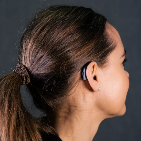 A woman is wearing a discreet Behind the Ear ReSound ONE 5/9  hearing aid 